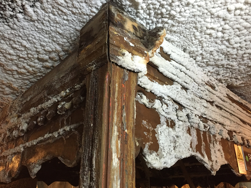 Massive Salzablagerungen mit warzenförmigen Salzknollen an Holzbauteilen im Bergwerk